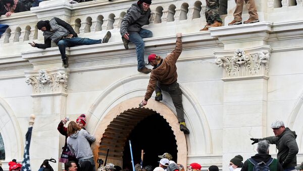 Supporters of U.S. President Donald Trump climb on walls at the U.S. Capitol during a protest against the certification of the 2020 U.S. presidential election results by the U.S. Congress, in Washington, U.S., January 6, 2021. - Sputnik International