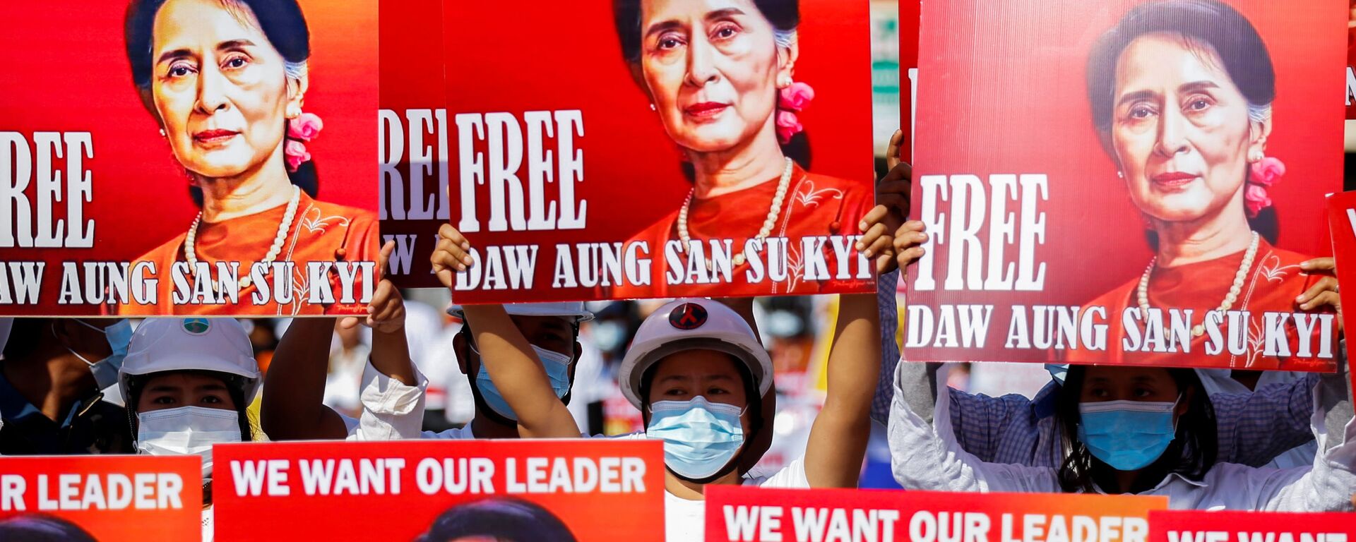 Demonstrators hold placards with the image of Aung San Suu Kyi during a protest against the military coup, in Naypyitaw, Myanmar, February 15, 2021.  - Sputnik International, 1920, 27.04.2022