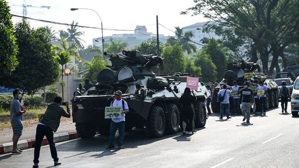 Protesters gather next to military vehicles parked along a street in downtown Yangon on February 15, 2021, the morning after Myanmar's military cut the nation's internet and deployed extra troops around the country. - Sputnik International