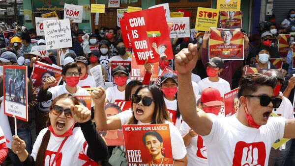 Protesters raise their hands with clenched fists during an anti-coup rally in front of the Myanmar Economic Bank in Mandalay, Myanmar on Monday, Feb. 15, 2021. - Sputnik International
