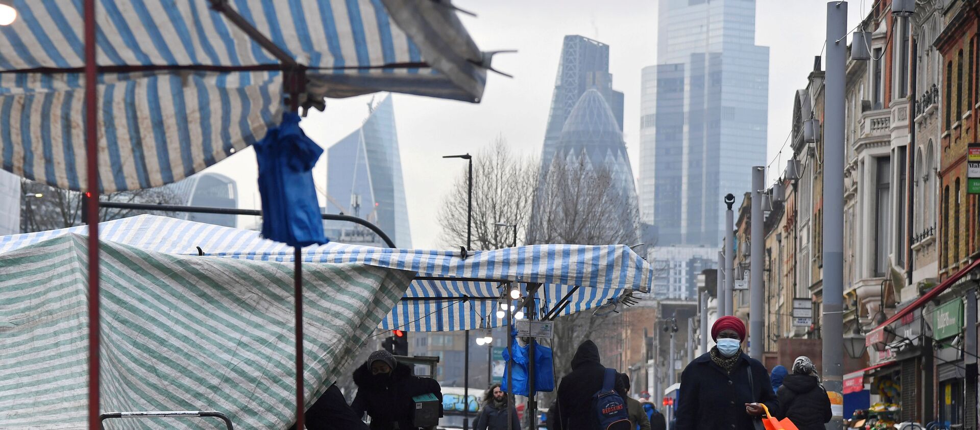 FILE PHOTO: People shop at market stalls, with skyscrapers of the CIty of London financial district seen behind, amid the coronavirus disease (COVID-19) pandemic, in London, Britain, January 15, 2021. REUTERS/Toby Melville/File Photo - Sputnik International, 1920, 28.02.2021