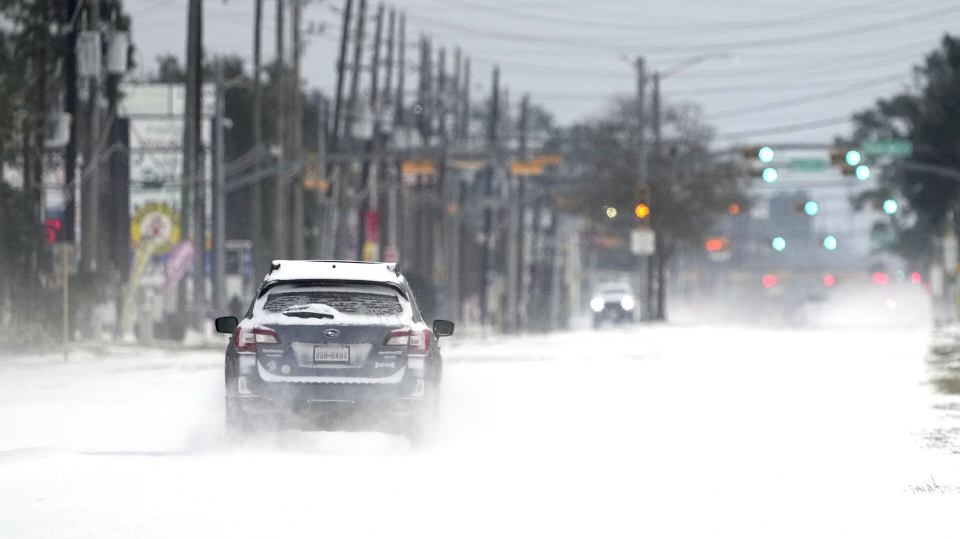 Vehicles drive on snow and sleet covered roads Monday, Feb. 15, 2021, in Spring, Texas. - Sputnik International, 1920, 27.02.2021