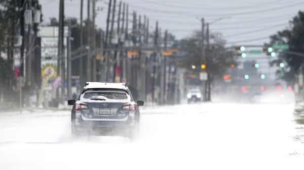 Vehicles drive on snow and sleet-covered roads on 15 February 2021, in Spring, Texas. - Sputnik International