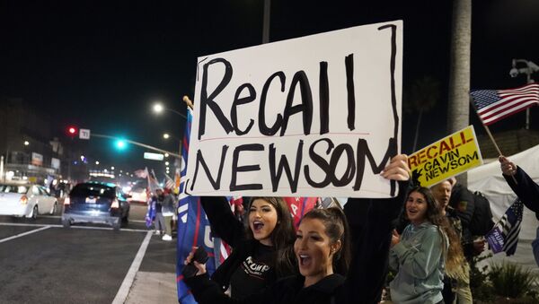 In this Nov. 21, 2020 file photo, demonstrators shout slogans while carrying a sign calling for the recall of Gov. Gavin Newsom during a protest against a stay-at-home order amid the COVID-19 pandemic in Huntington Beach, Calif - Sputnik International