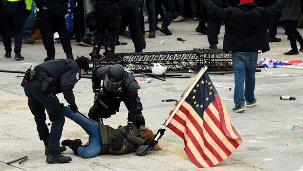 In this file photo taken on January 6, 2021, police detain a person as supporters of US President Donald Trump riot outside the US Capitol in Washington, DC. - - Sputnik International