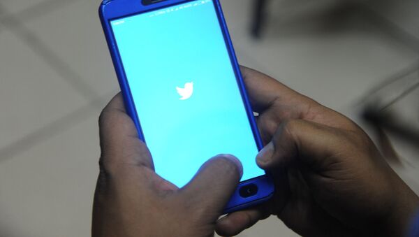 An Indian man poses for a photograph using Twitter on his cellpohne in Siliguri on March 27, 2018 - Sputnik International