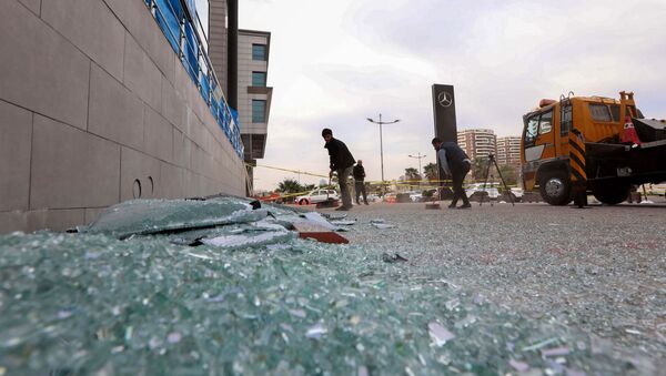 A worker cleans shattered glass on February 16, 2021 outside a damaged shop following a rocket attack the previous night in Arbil, the capital of the northern Iraqi Kurdish autonomous region - Sputnik International