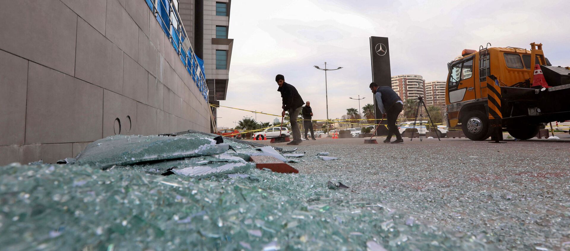 A worker cleans shattered glass on February 16, 2021 outside a damaged shop following a rocket attack the previous night in Arbil, the capital of the northern Iraqi Kurdish autonomous region - Sputnik International, 1920, 17.02.2021
