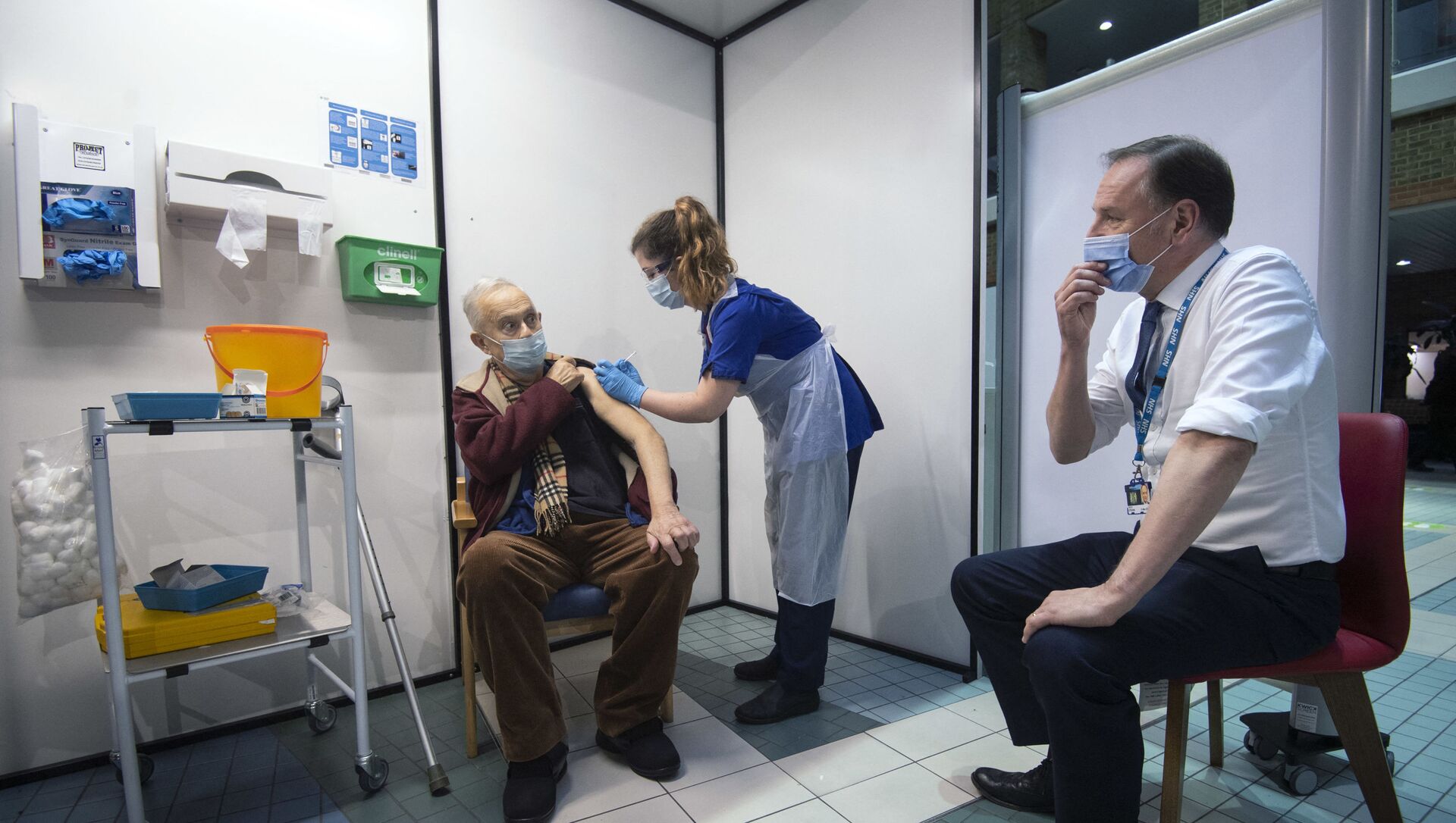 Simon Stevens (R), Chief Executive of the NHS, watches as a nurse (C) administers a dose of the Pfizer-BioNTech Covid-19 vaccine to Frank Naderer (L), 82, at Guy's Hospital in London on December 8, 2020 as the UK starts its biggest ever vaccination programme. - Sputnik International, 1920, 17.02.2021
