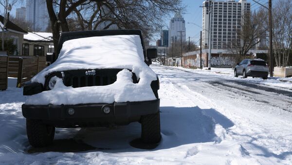 A parked Jeep is covered in snow Tuesday, Feb. 16, 2021, in Austin, Texas. Temperatures dropped into the single digits as snow shut down air travel and grocery stores. - Sputnik International