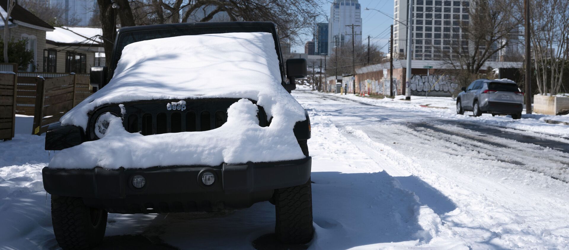 A parked Jeep is covered in snow Tuesday, Feb. 16, 2021, in Austin, Texas. Temperatures dropped into the single digits as snow shut down air travel and grocery stores. - Sputnik International, 1920