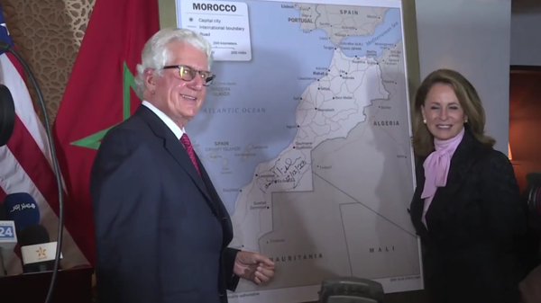 US Ambassador to Morocco David Fischer signs a new map of Morocco on December 13, 2020, that includes the disputed territory of Western Sahara as part of Moroccan territory, which US President Donald Trump had just recognized. - Sputnik International