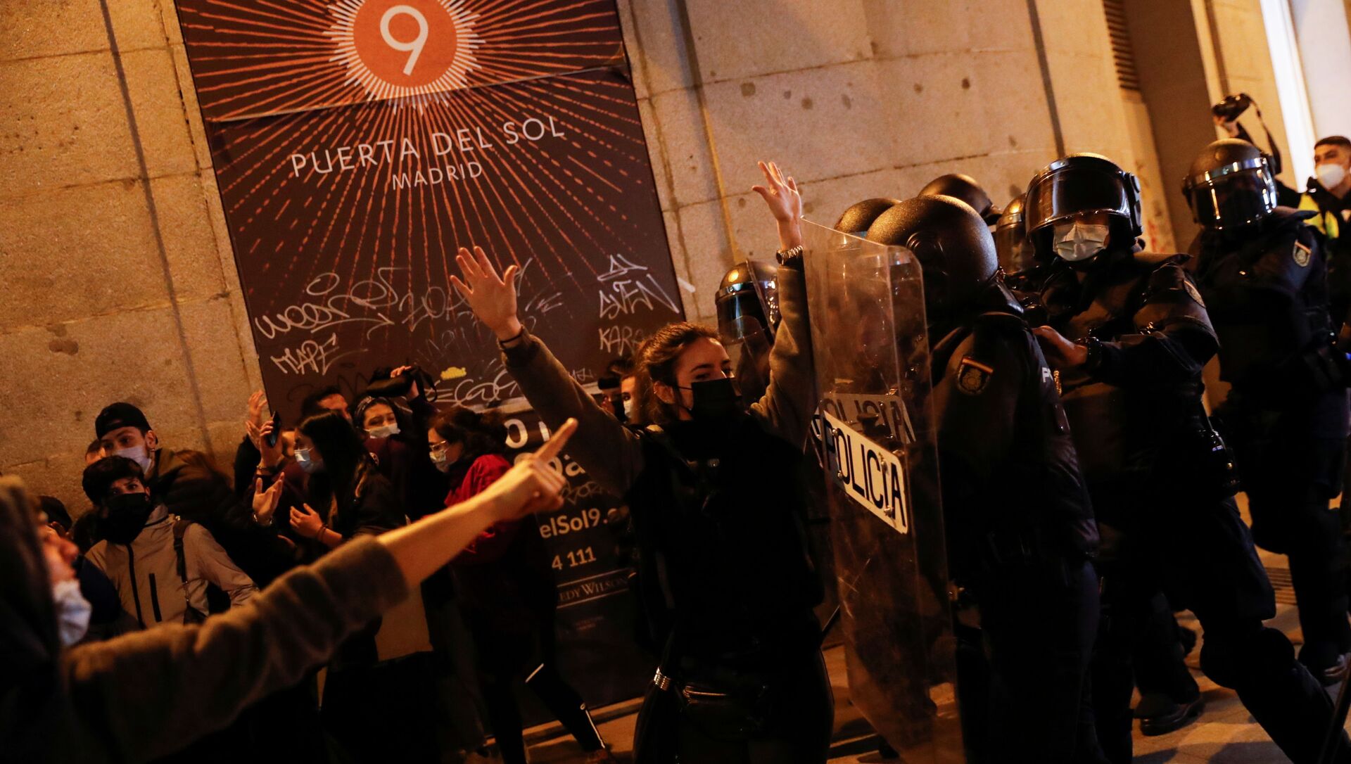 A person raises the hands in front of police officers as supporters of Catalan rapper Pablo Hasel protest against his arrest in Madrid, Spain, February 17, 2021. - Sputnik International, 1920, 17.02.2021