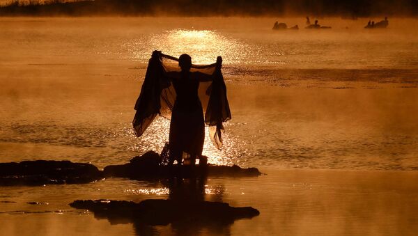 An Indian woman washes a sari in the Narmada River at sunrise on a foggy winter morning in Jabalpur in Madhya Pradesh state on January 2, 2019 - Sputnik International