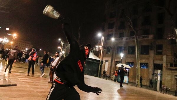A demonstrator throws an object during a protest in support of Catalan rapper Pablo Hasel, after he was given a jail sentence on charges of glorifying terrorism and insulting royalty in his songs, in Barcelona, Spain, February 19, 2021 - Sputnik International