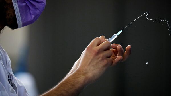 A medical worker prepares to administer a vaccination against the coronavirus disease (COVID-19) at a temporary Clalit Healthcare Maintenance Organization (HMO) centre, at a sports hall in Netivot, Israel February 4, 2021 - Sputnik International