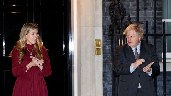 Britain's Prime Minister Boris Johnson and partner Carrie Symonds applaud outside 10 Downing Street during a national clap for late Captain Sir Tom Moore and NHS workers, amidst the coronavirus disease (COVID-19) outbreak, in London, Britain, February 3, 2021.  - Sputnik International