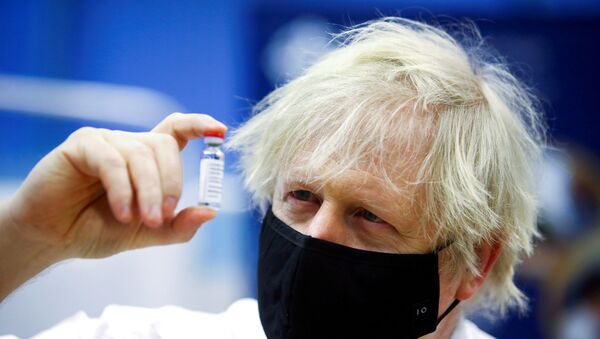 FILE PHOTO: Britain's Prime Minister Boris Johnson holds a vial of an Oxford-AstraZeneca COVID-19 vaccine, during his visit at a vaccination centre at Cwmbran Stadium in Cwmbran, south Wales, Britain February 17, 2021. Geoff Caddick/Pool via REUTERS/File Photo - Sputnik International
