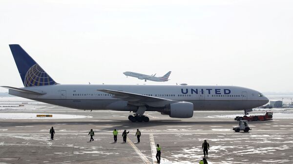 A United Airlines Boeing 777-200ER  plane is towed as an American Airlines Boeing 737 plane departs from O'Hare International Airport in Chicago, Illinois, U.S. Nov. 30, 2018.  - Sputnik International