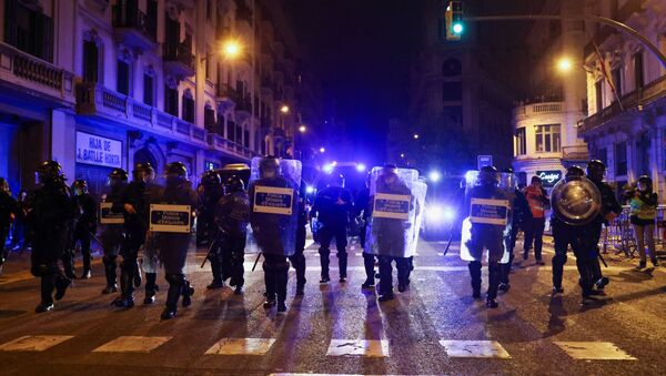 Police officers walk during a protest in support of rap singer Pablo Hasel after he was given a jail sentence on charges of glorifying terrorism and insulting royalty in his songs, in Barcelona, Spain, February 21, 2021. - Sputnik International