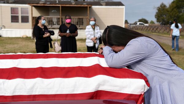 Lila Blanks holds the casket of her husband, Gregory Blanks, 50, who died of the coronavirus disease (COVID-19), ahead of his funeral in San Felipe, Texas, U.S., January 26, 2021 - Sputnik International