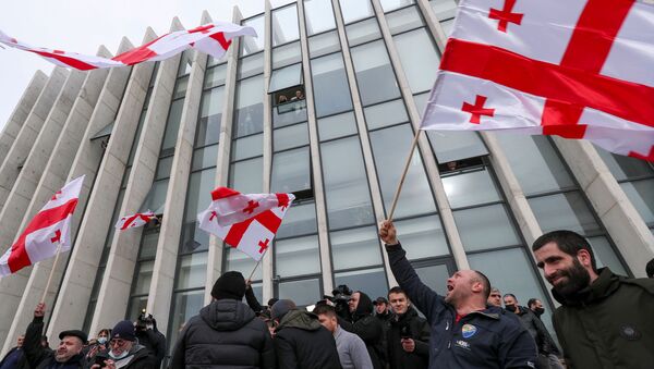 Opposition supporters wave flags following the announcement of Georgian Prime Minister Giorgi Gakharia's resignation outside the headquarters of the United National Movement (UNM) party in Tbilisi, Georgia February 18, 2021. - Sputnik International