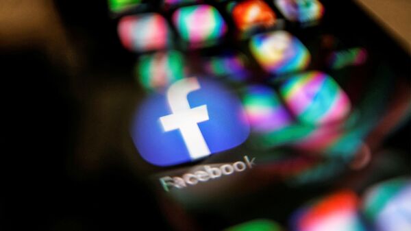 The Facebook logo displayed on a mobile phone is seen through a magnifying glass in this picture illustration taken February 9, 2021 - Sputnik International