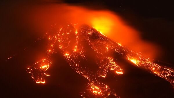 Streams of red hot lava flow as Mount Etna, Europe's most active volcano, erupts, seen from Giarre, Italy, February 16, 2021. - Sputnik International