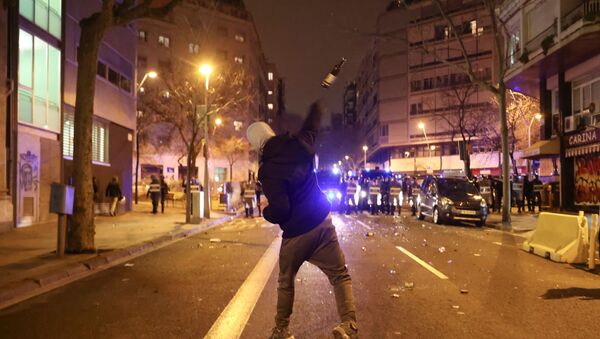 A demonstrator throws a bottle towards police during a protest in support of rap singer Pablo Hasel, after he was given a jail sentence on charges of glorifying terrorism and insulting royalty in his songs, in Barcelona, Spain, February 23, 2021 - Sputnik International