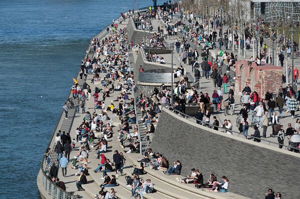 People spend time in the sun on the banks of the Rhine amid the coronavirus disease (COVID-19) pandemic in Cologne, Germany, 21 February 2021.  - Sputnik International