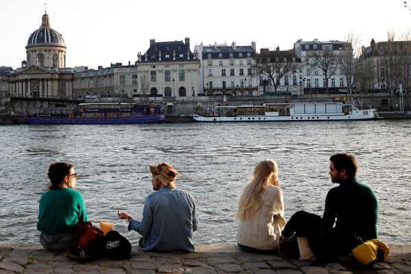 People enjoy sunny, warm weather sitting on the banks of the Seine in Paris amid the coronavirus disease (COVID-19) outbreak in France, 24 February 2021. - Sputnik International