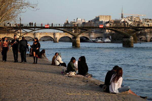People enjoy a sunny and warm weather sitting on the banks of the Seine in Paris amid the coronavirus disease (COVID-19) outbreak in France, 24 February 2021.  - Sputnik International