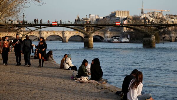 People enjoy a sunny and warm weather sitting on the banks of the River Seine in Paris amid the coronavirus disease (COVID-19) outbreak in France on 24 February 2021.  - Sputnik International