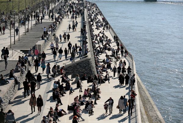 People spend time in the sunshine on the banks of the Rhine amid the coronavirus disease (COVID-19) pandemic in Cologne, Germany, 21 February 2021.  - Sputnik International