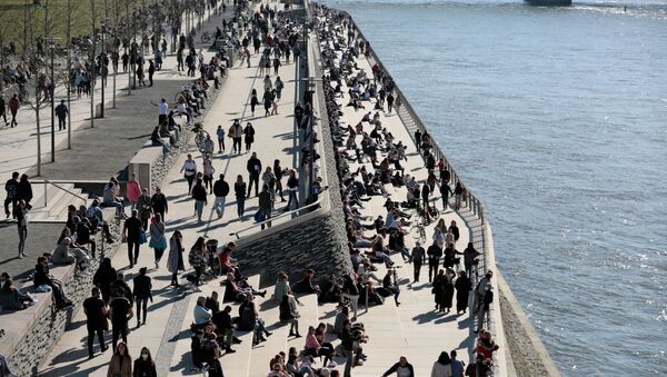 People spend time in the sunshine on the banks of the river Rhine amid the coronavirus disease (COVID-19) pandemic in Cologne, Germany, on 21 February 2021.  - Sputnik International