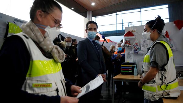 French Junior Transport Minister Jean-Baptiste Djebbari talks with medical workers in a COVID-19 testing centre during a visit on police measures and sanitary checks at Paris Charles de Gaulle airport in Roissy near Paris as France closed borders to travelers outside European Union due to restrictions against the spread of the coronavirus disease (COVID-19) in France, February 5, 2021 - Sputnik International