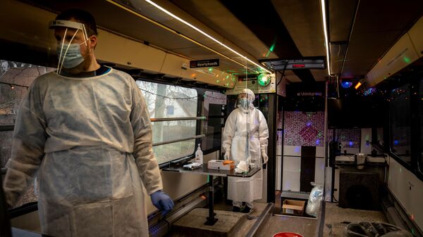 Healthcare workers wait in the Partybus, where people can listen to music while being tested for the coronavirus disease (COVID-19), in Ishoej, Denmark February 23, 2021 - Sputnik International