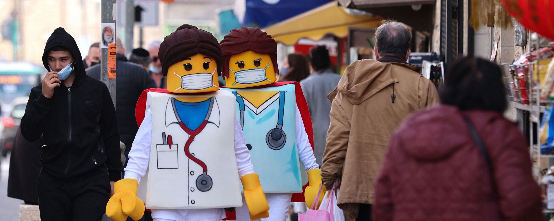 People dressed as Lego medical personnel walk past shops in Jerusalem on February 24, 2021, a day before the Jewish holiday of Purim - Sputnik International, 1920, 13.04.2022