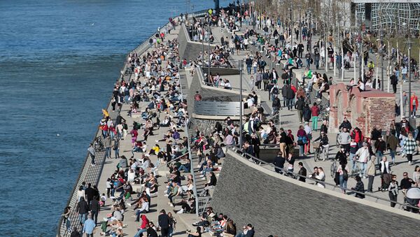 People spend time in the sunshine on the banks of the river Rhine amid the coronavirus disease (COVID-19) pandemic in Cologne, Germany, 21 February 2021.  - Sputnik International