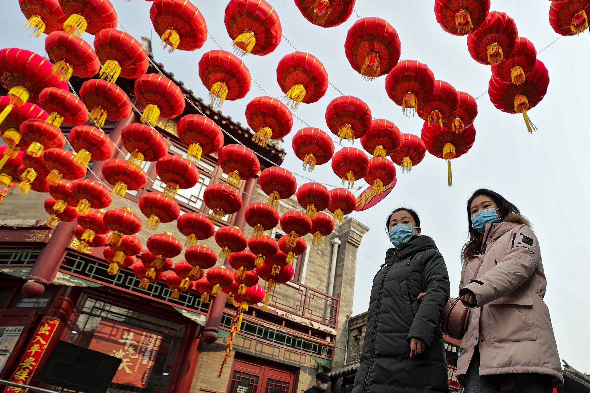 Девушки в защитных масках на украшенной улице в Пекине - Sputnik International, 1920, 16.12.2022