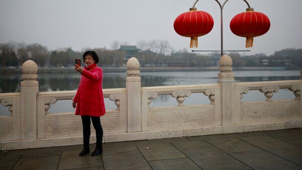 Девушка делает селфи на украшенной улице в Пекине - Sputnik International