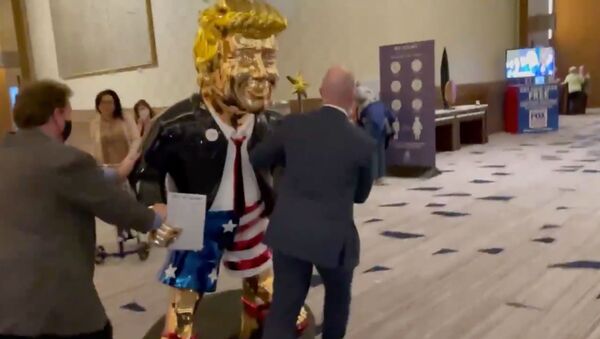 Screenshot captures golden statue of former US President Donald Trump being wheeled toward an event associated with the annual Conservative Police Action Conference. - Sputnik International