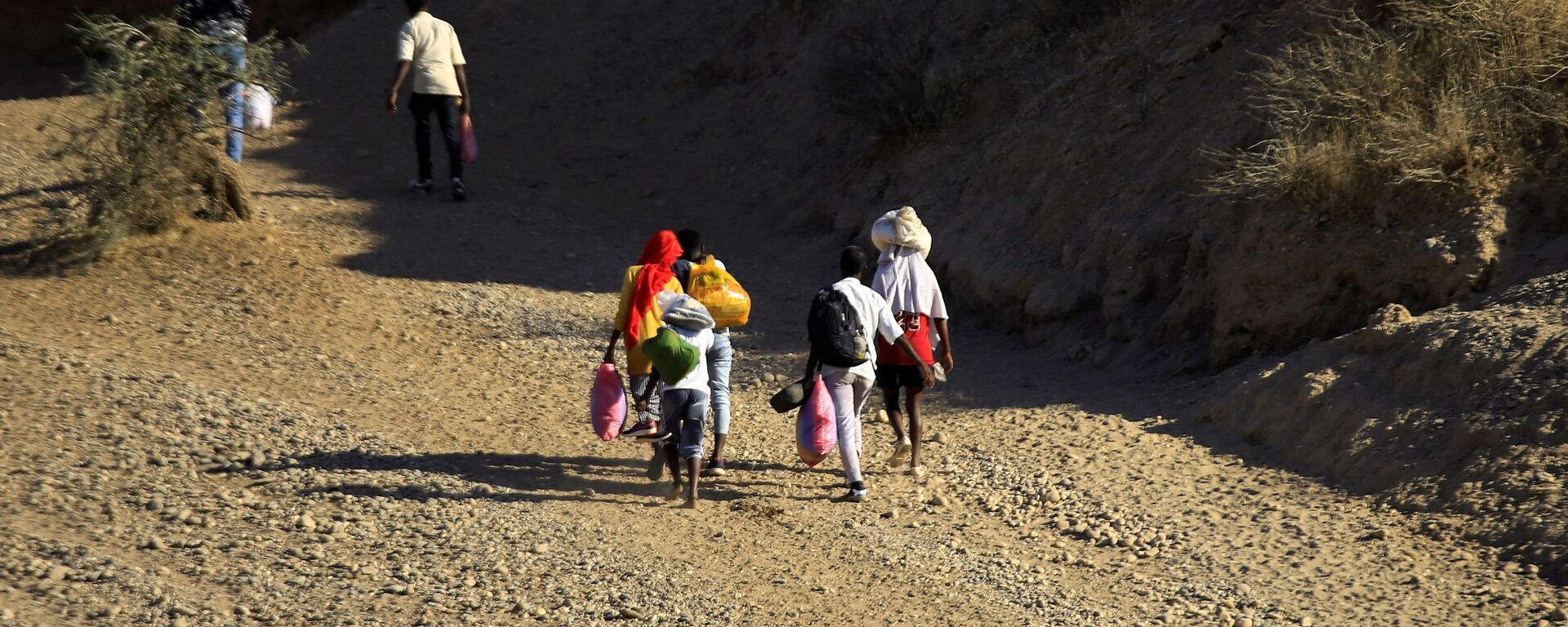 Ethiopians, who fled the ongoing fighting in Tigray region, carry their belongings after crossing the Setit River on the Sudan-Ethiopia border, in the eastern Kassala state, Sudan December 16, 2020. REUTERS/Mohamed Nureldin Abdallah/File Photo - Sputnik International, 1920, 02.03.2021