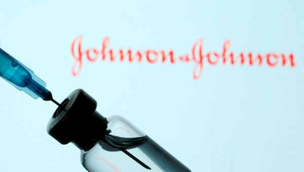 A vial and sryinge are seen in front of a displayed Johnson&Johnson logo in this illustration taken January 11, 2021 - Sputnik International