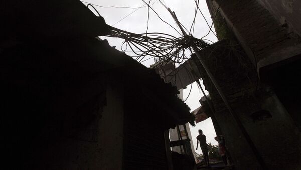 An Indian girl walks a narrow lane beneath a power pole with high-voltage cables coiling around at a slum in Mumbai, India, Friday, Aug. 3, 2012 - Sputnik International