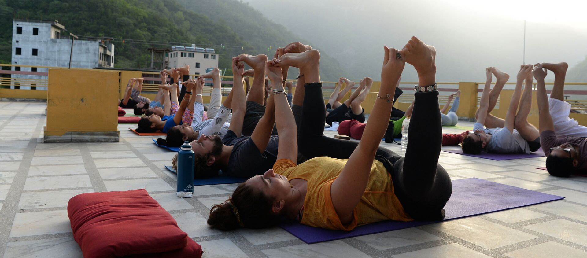 This picture taken on June 19, 2018, shows people practising yoga on a terrace at the Anand Prakash yoga ashram in Rishikesh in India's Uttarakhand state - Sputnik International, 1920, 01.03.2021