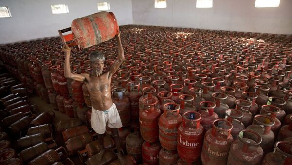 An Indian laborer sorts Liquid Petroleum Gas (LPG) cylinders used for cooking at a warehouse after downloading them from  a truck in Allahabad, India, Monday, Aug.1, 2016 - Sputnik International