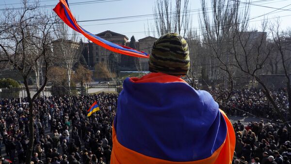 An opposition supporter wrapped in a national flag attends a rally to demand the resignation of Armenian Prime Minister Nikol Pashinyan, in Yerevan, Armenia February 27, 2021 - Sputnik International