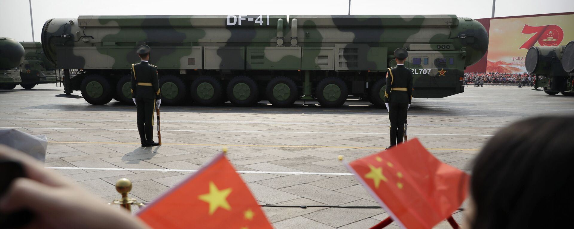 FILE - In this Oct. 1, 2019, file photo spectators wave Chinese flags as military vehicles carrying DF-41 ballistic missiles roll during a parade to commemorate the 70th anniversary of the founding of Communist China in Beijing. Trucks carrying weapons including a nuclear-armed missile designed to evade U.S. defenses rumbled through Beijing as the Communist Party celebrated its 70th anniversary in power - Sputnik International, 1920, 01.03.2021