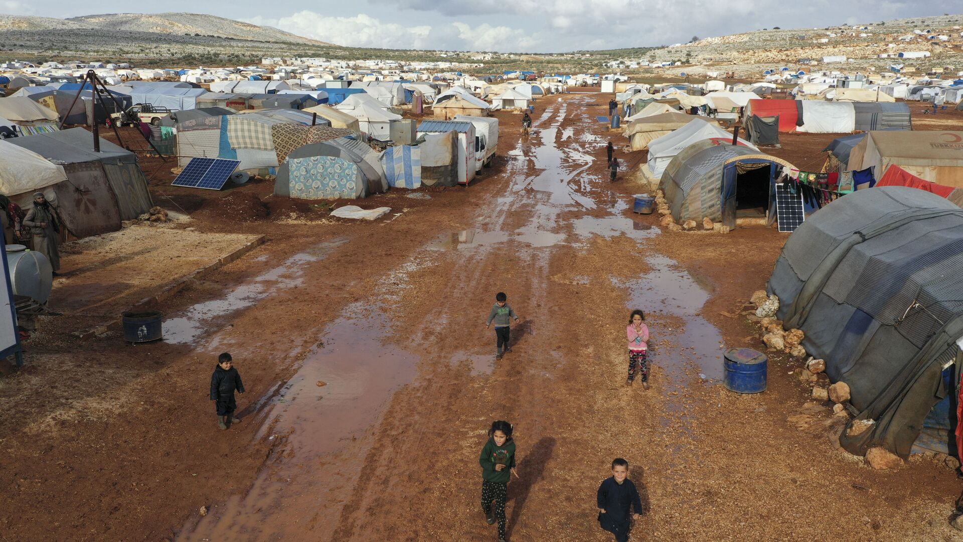 Syrian refugees walk through a camp for displaced muddied by recent rains near the village of Kafr Aruq , in Idlib province, Syria, Thursday, Jan. 28, 2021. - Sputnik International, 1920, 06.03.2021